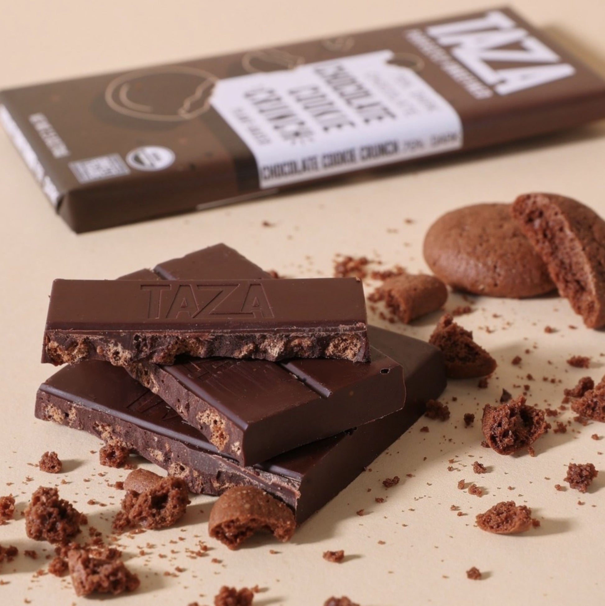 Chocolate Cookie Crunch Bars, wrapped and unwrapped surrounded by chocolate cookie crumbles.