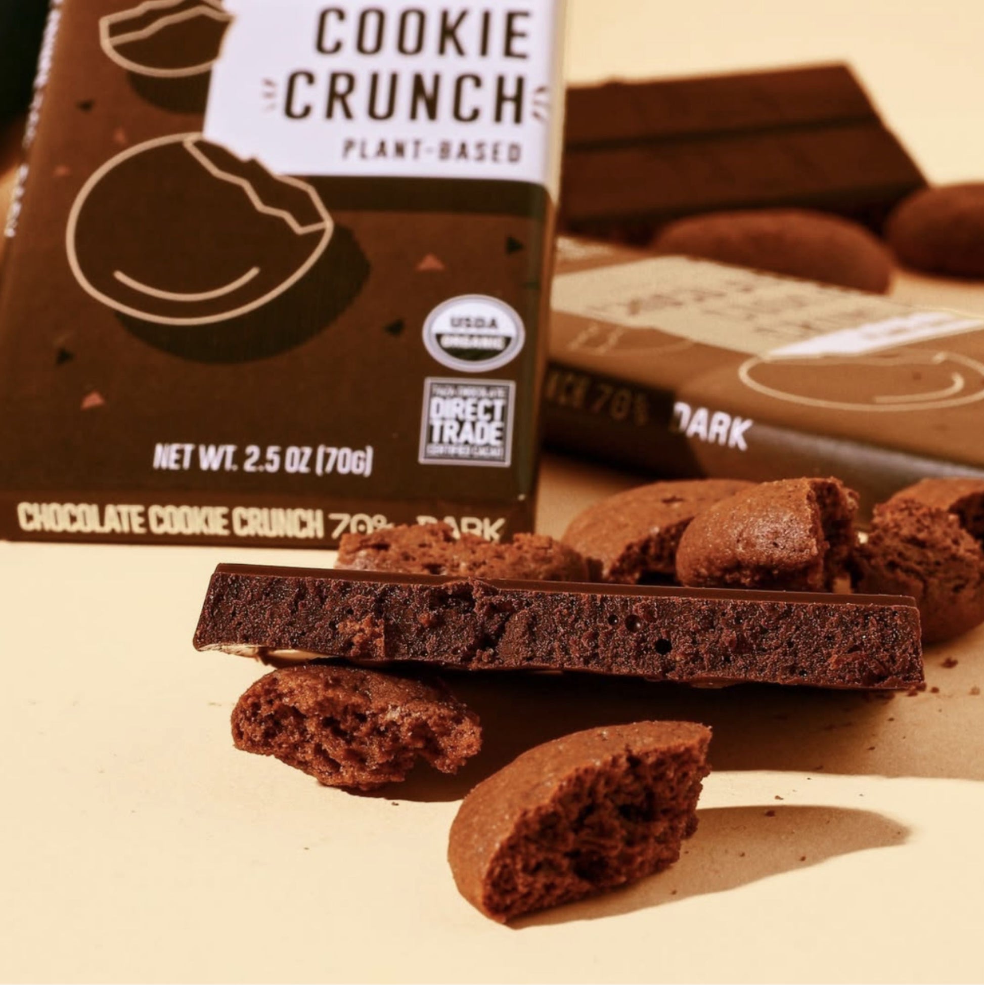 Chocolate Cookie Crunch Bars, wrapped and unwrapped surrounded by chocolate cookie crumbles.