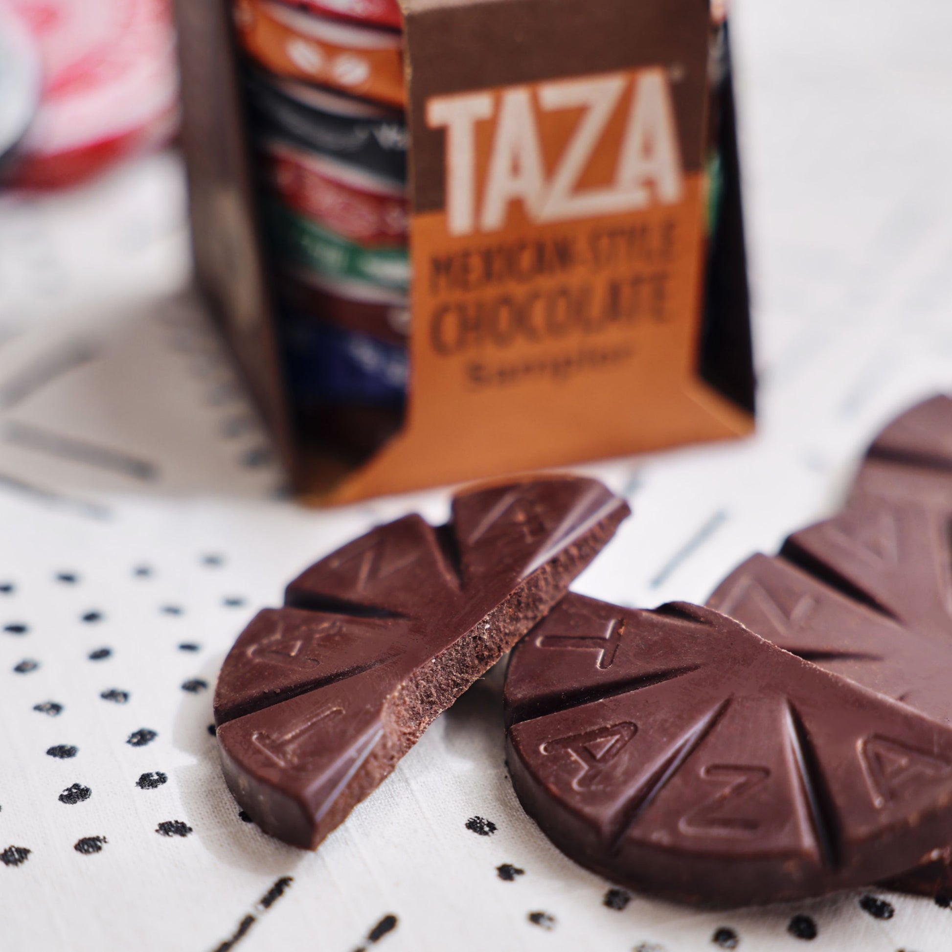 Closeup of Mexican-Style Chocolate Sampler, and an unwrapped, snapped in half Chocolate Disc.