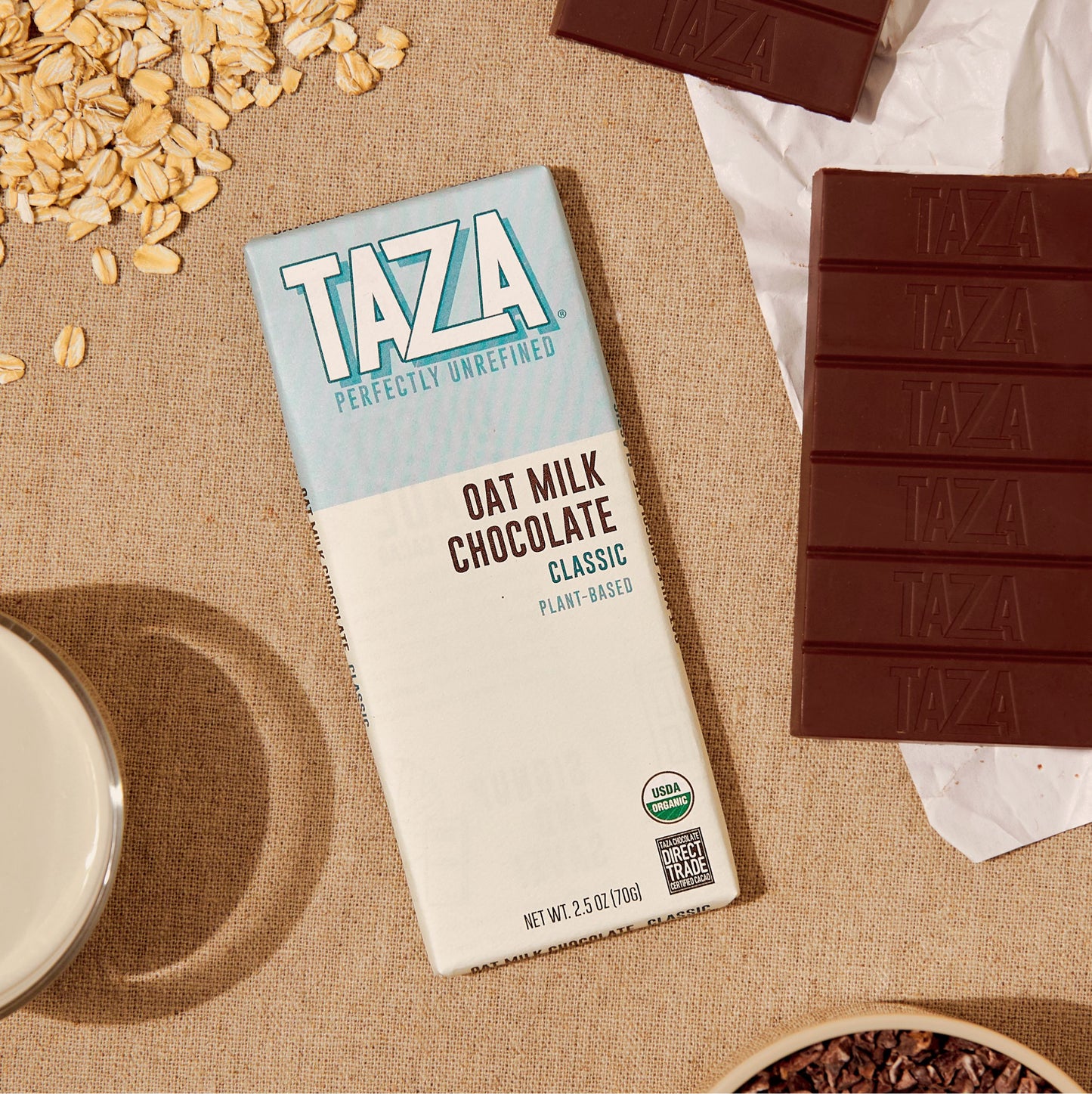 Classic Oat Milk Bar laying next to unwrapped chocolate and oats.