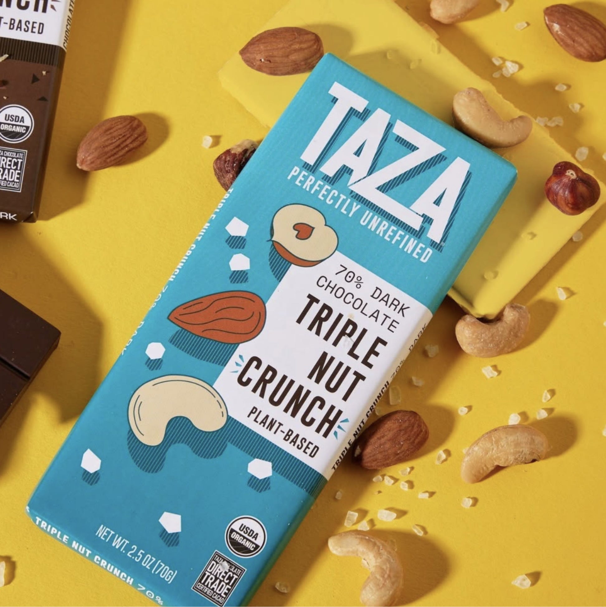 Triple Nut Crunch Bar laying next to scattered nuts and salt.
