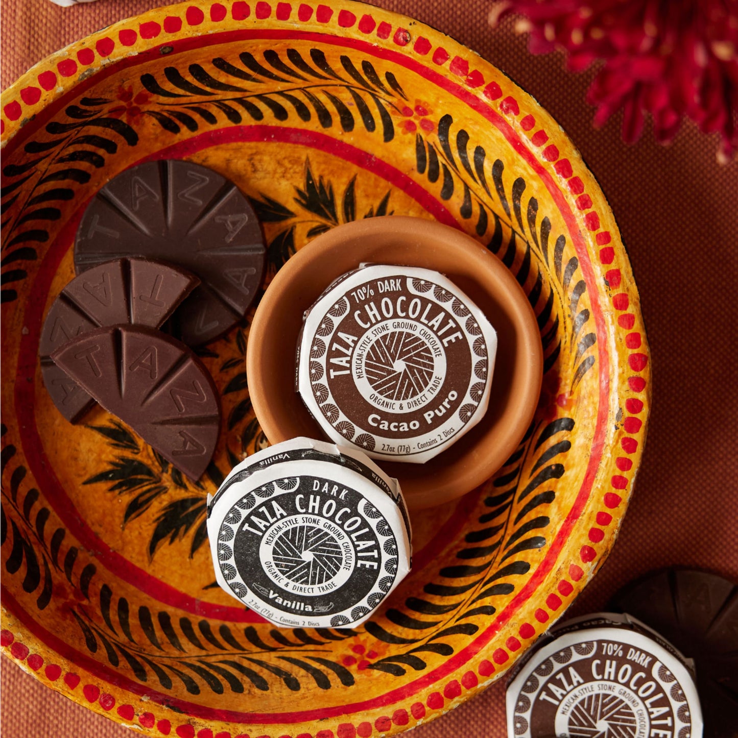 Cacao Puro Disc lying next to unwrapped chocolate.
