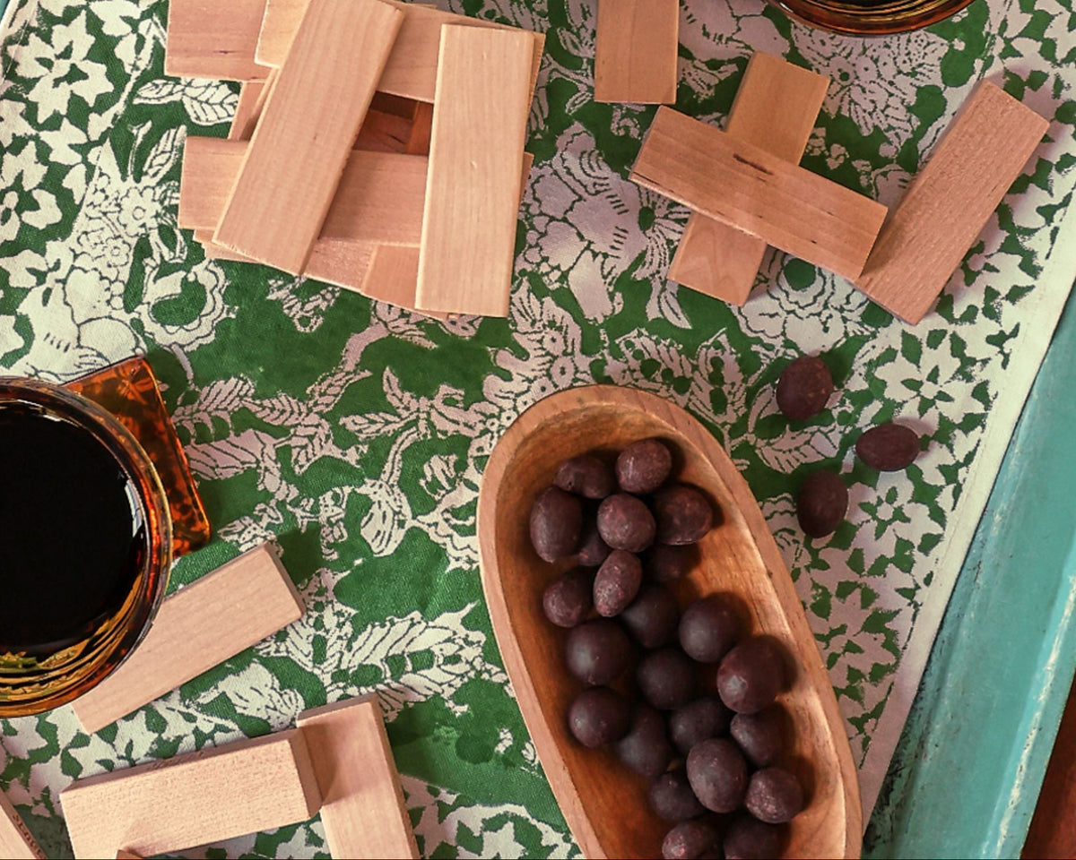 Bag of Chocolate Covered Cashews in a family game night setting with an open bowl of chocolate covered cashews.