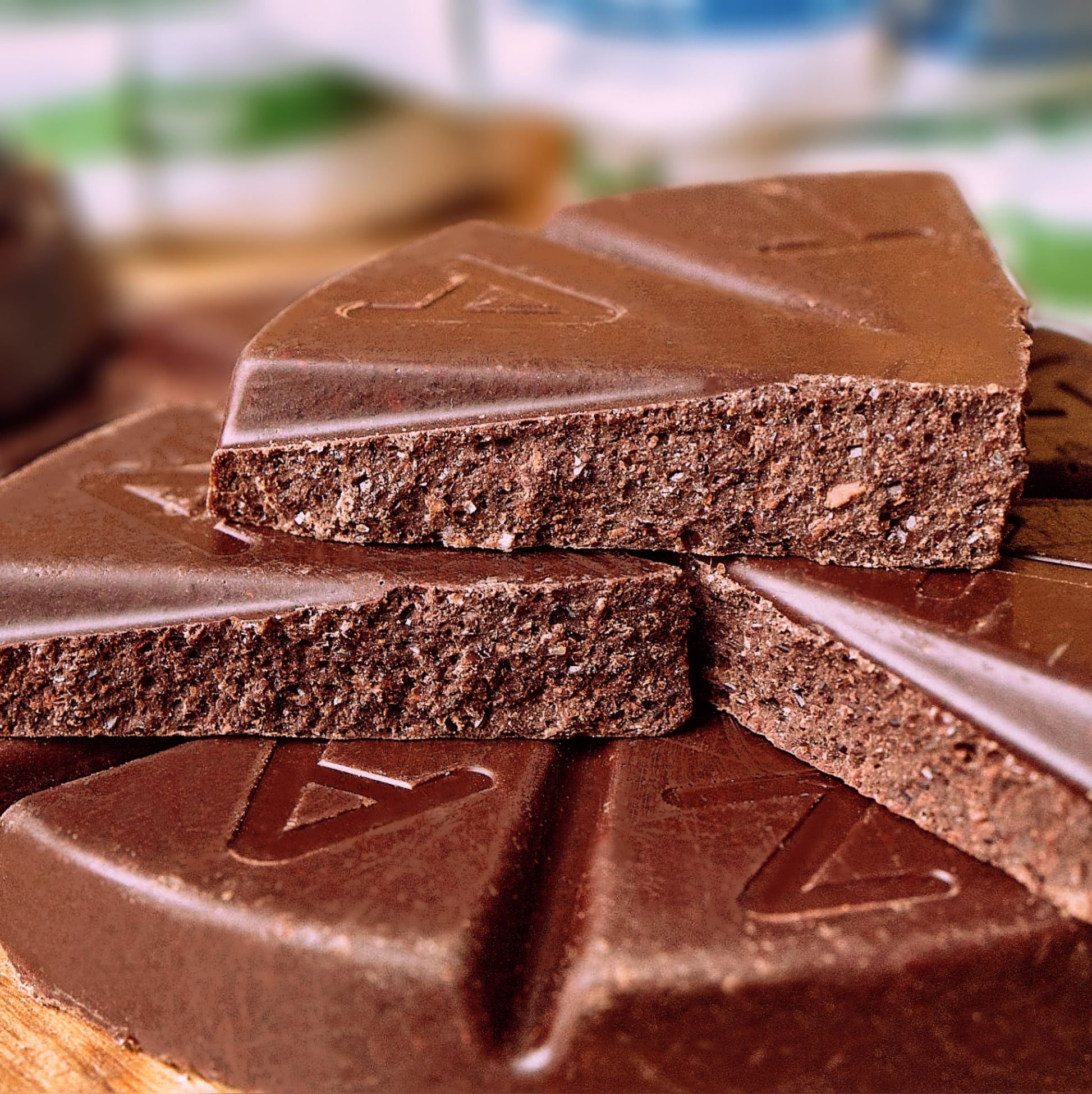 Close up shot of unwrapped and snapped in half chocolate discs, showing the rich stone-ground chocolate texture.