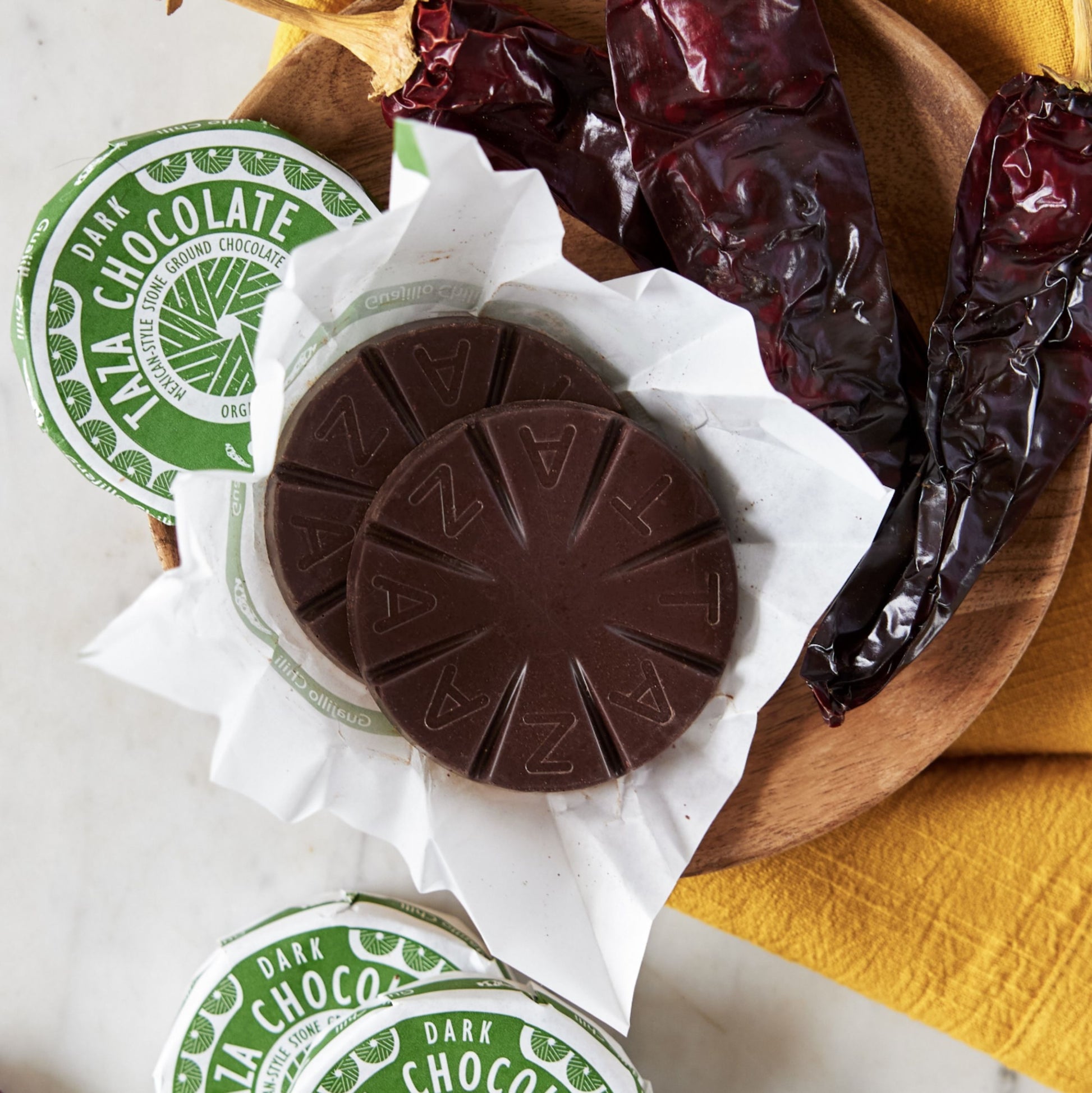 Unwrapped Guajillo Disc Surrounded by dried guajillo peppers.