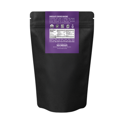 Back of a  black stand-up pouch of Taza Chocolate Organic Chocolate Covered Raisins, featuring a purple label with product details and nutrition facts on a white background.